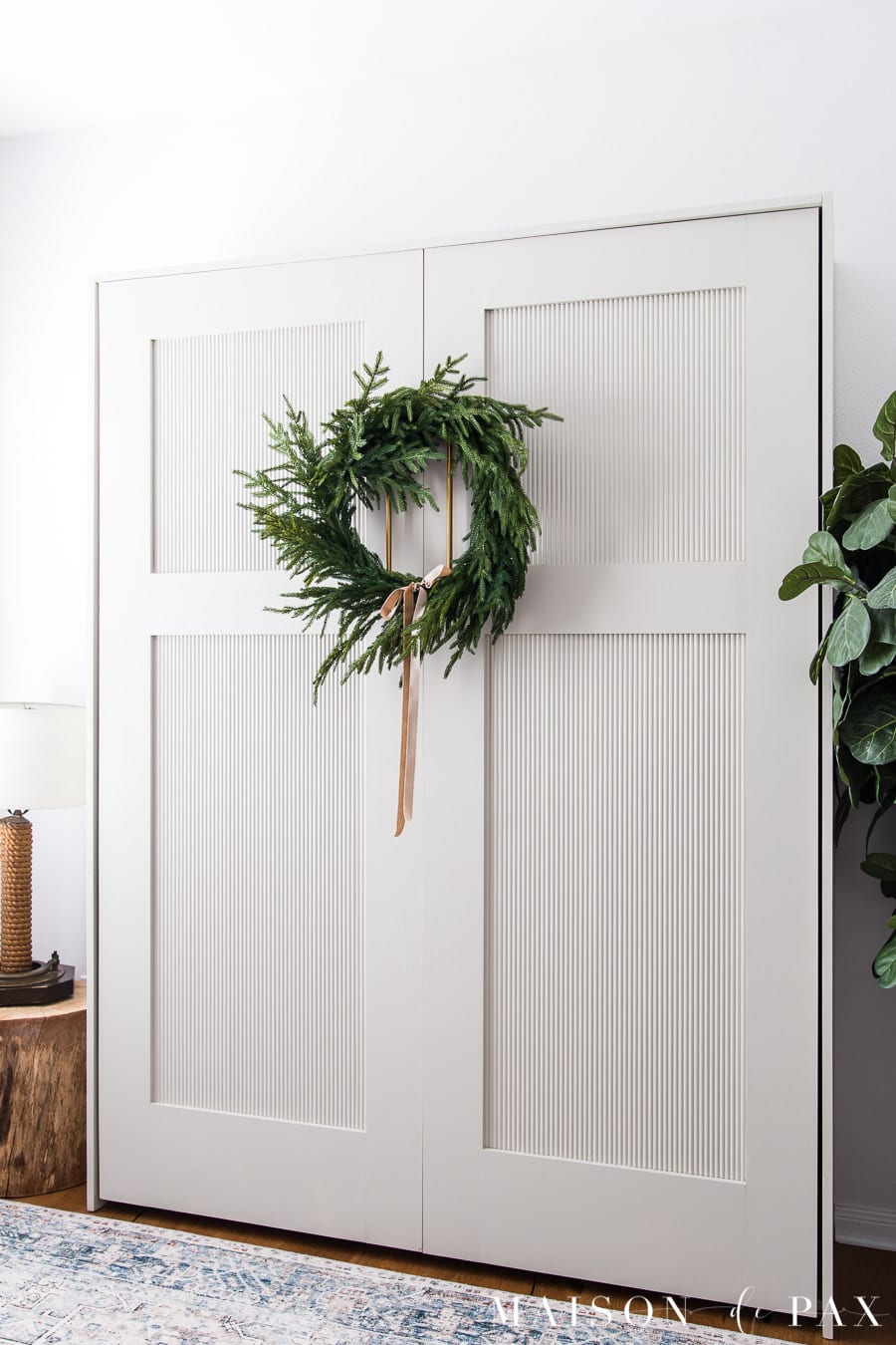 fluted cabinet with wreath and velvet ribbon