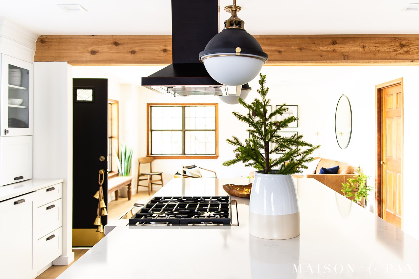 gold bells hanging on door knob and mini tree in crock on kitchen island | Maison de Pax