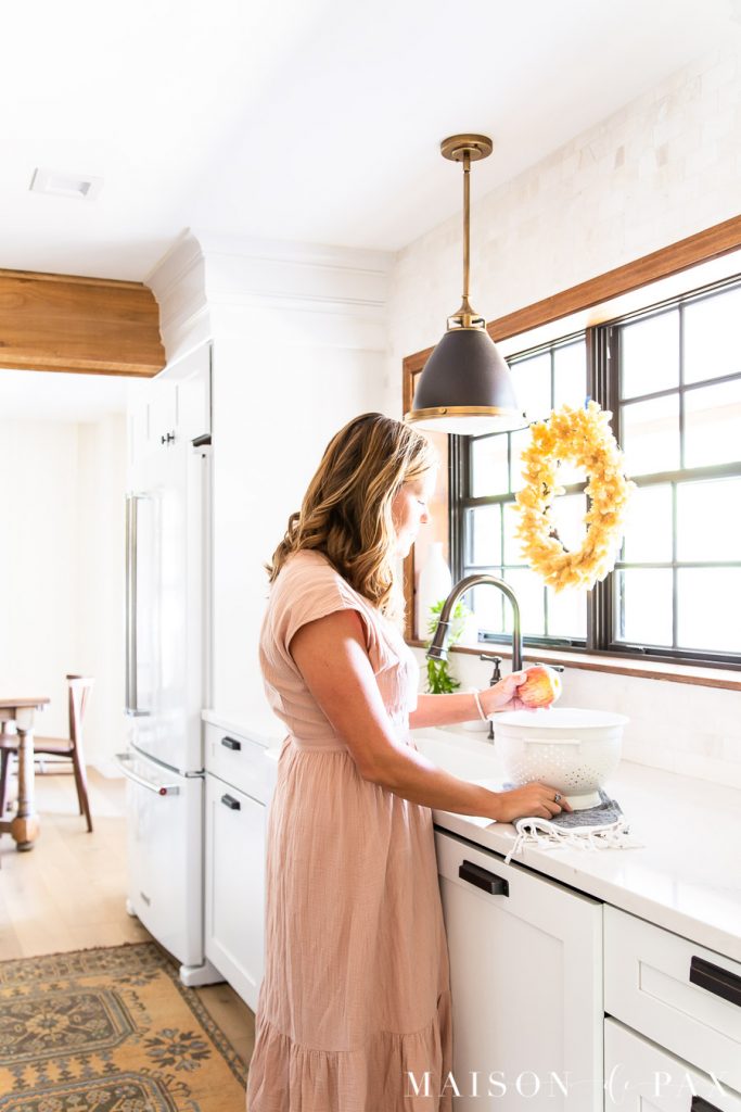 woman with colander of apples in farmhouse kitchen | Maison de Pax