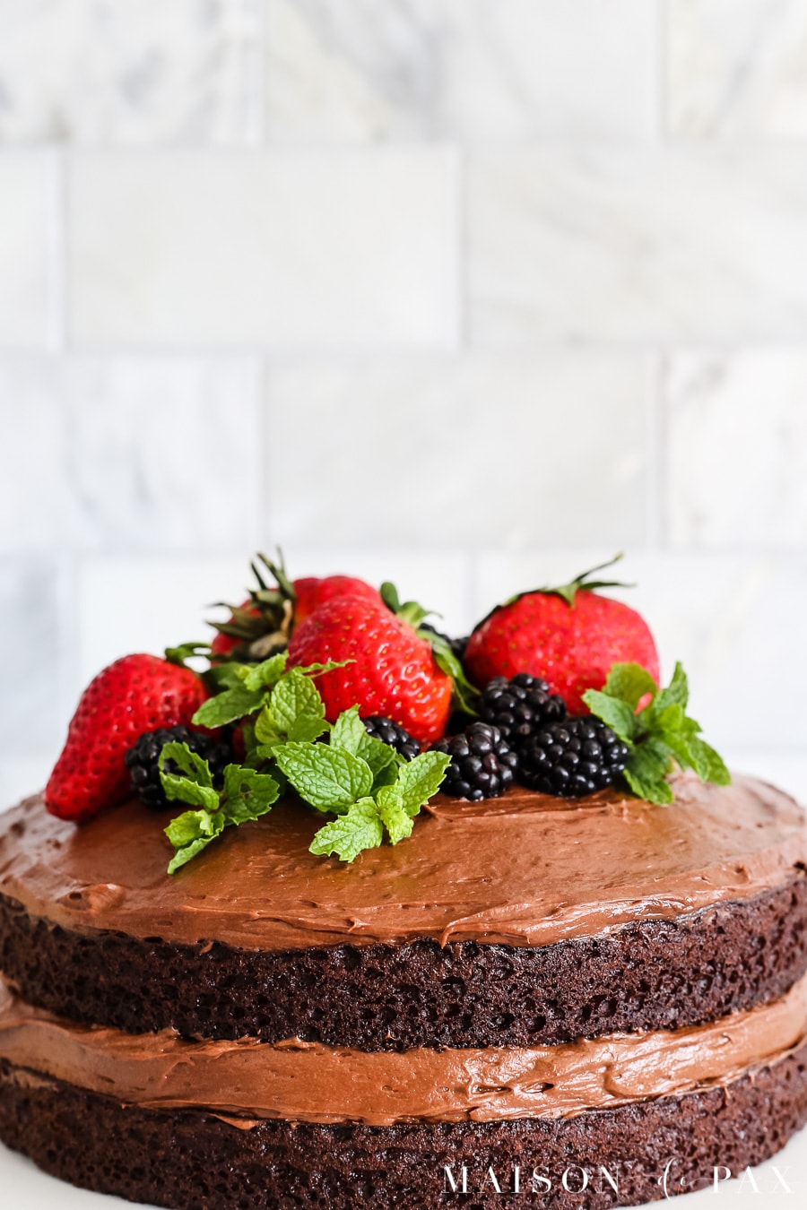 Chocolate naked cake with fruit on top! Learn how to make a naked cake. #nakedcake #nakedcakerecipe #cakefrosting #howtofrost #cakerecipe #creamcheesefrosting #cakedecorating #chocolatecake 