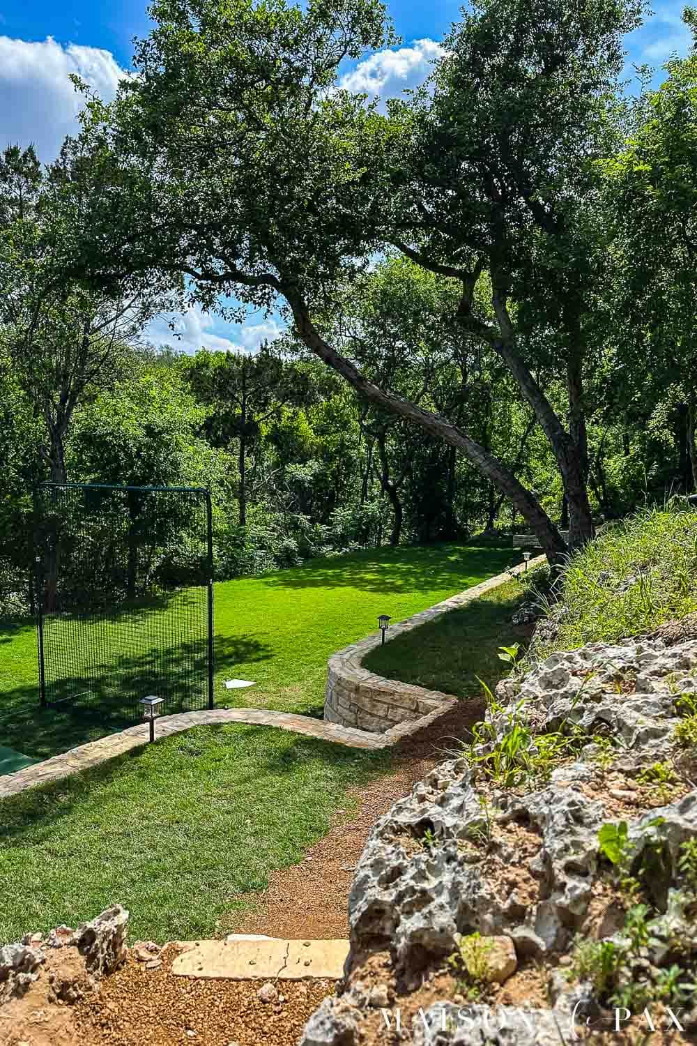 neatly manicured crushed granite pathway and lawn with limestone retaining wall