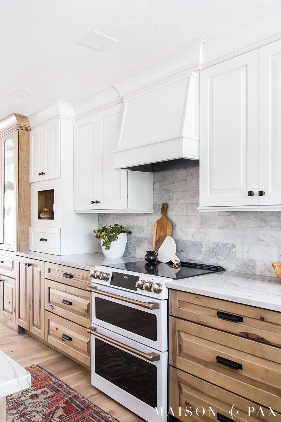 white cabinets and vent hood above range