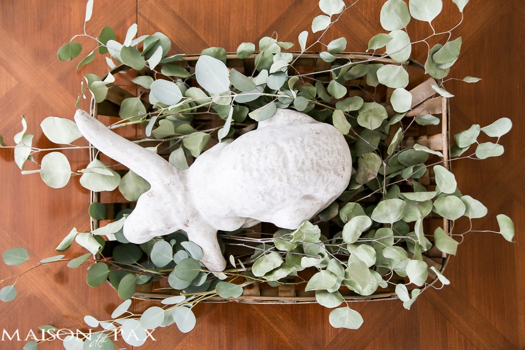 What a cute, simple idea for Easter decor! Use a garden statue bunny in a basket with dried greens as a centerpiece for your table | aiweb9ygdry.cmersite.com