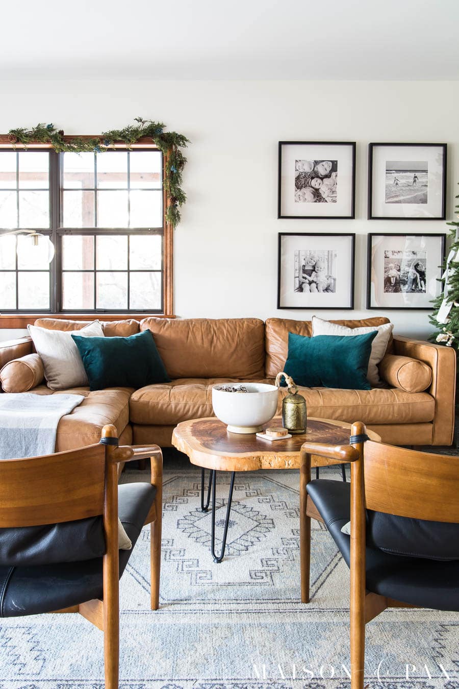tan leather sofa with green velvet pillows and garland for holiday decorations | Maison de Pax
