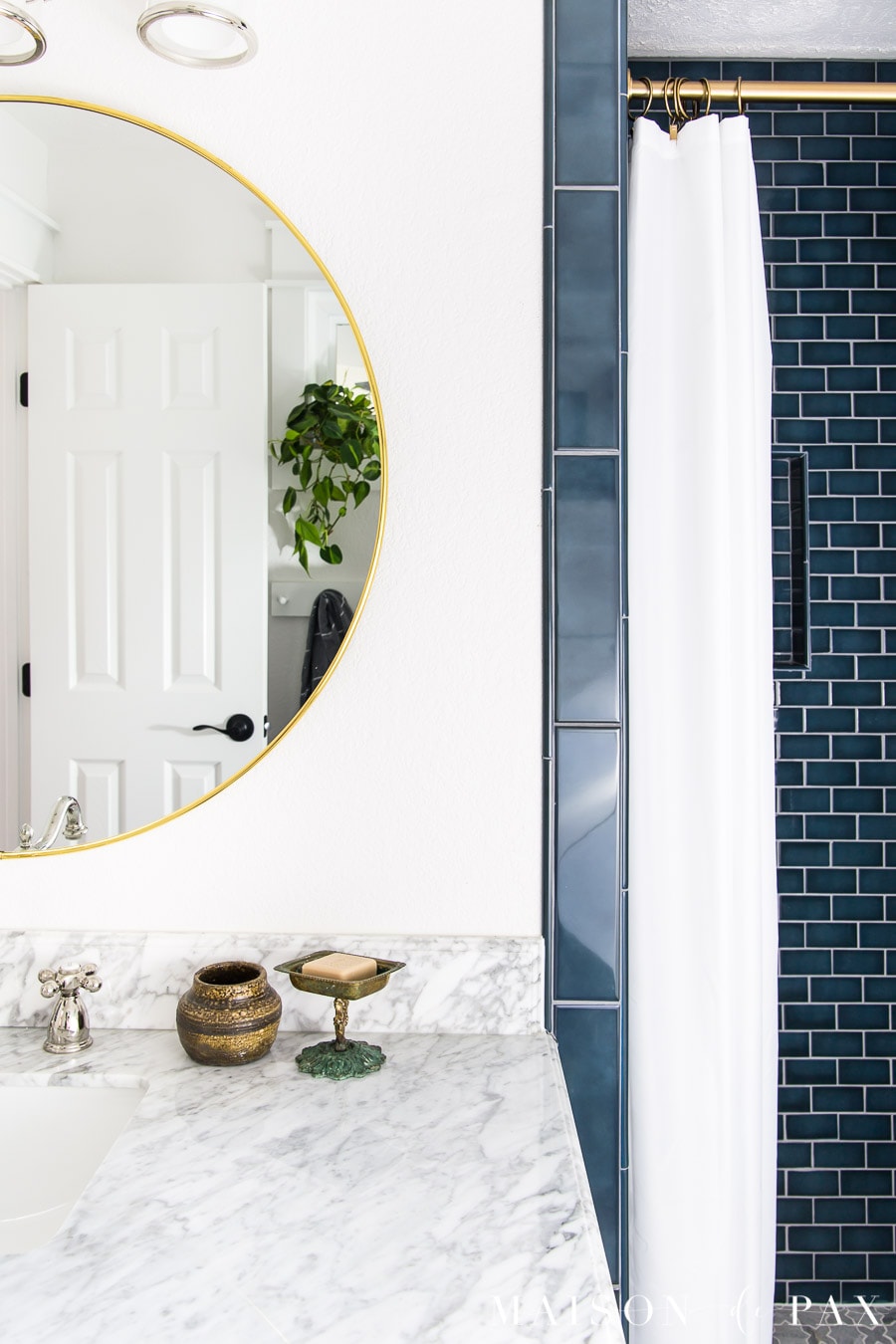 marble countertops and blue shower tile in blue and white bathroom