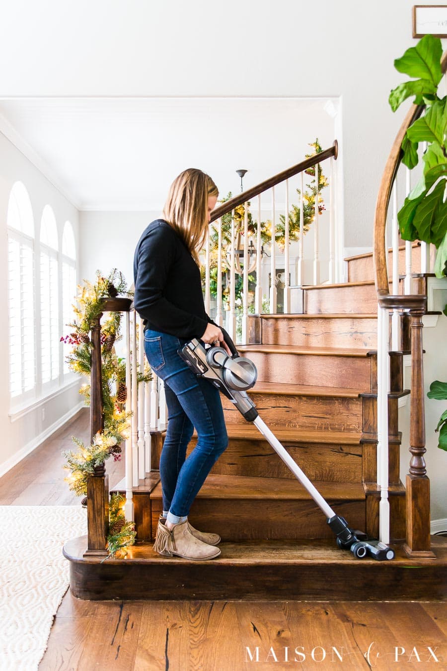woman using cordless vacuum on stairs | Maison de Pax