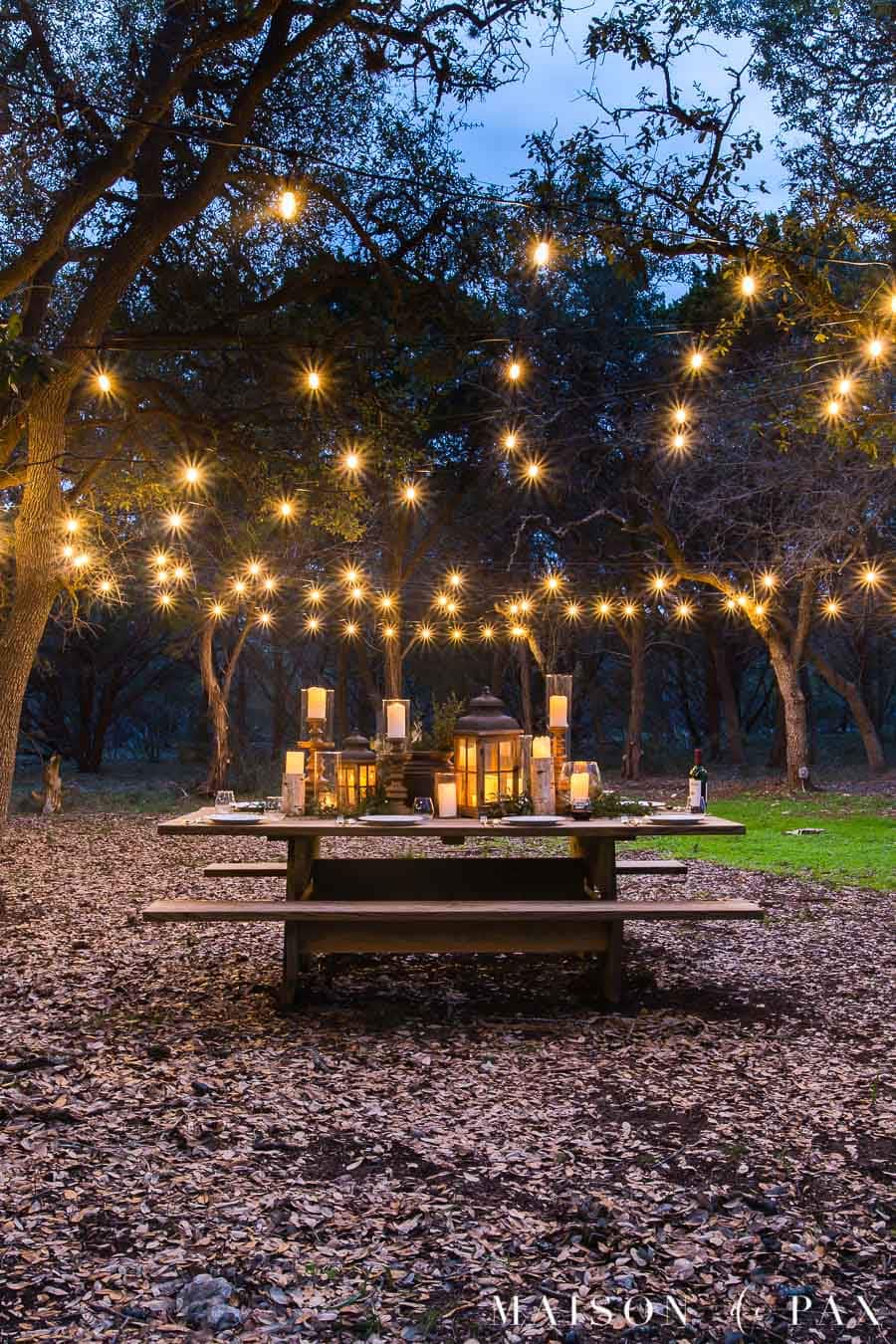 picnic table with globe string lights hanging above | Maison de Pax