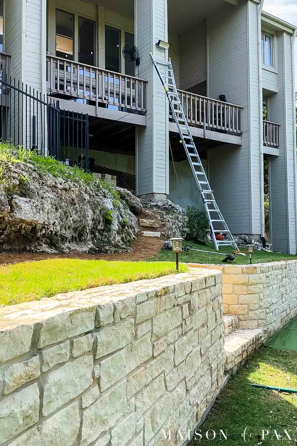 25' extension ladder set against house to install sport court led light