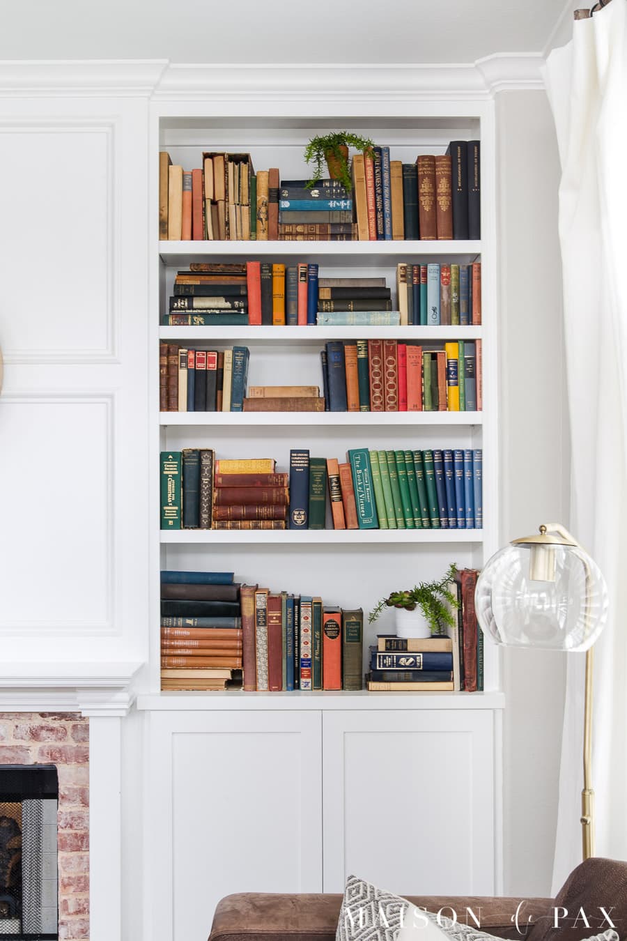 colorful antique books in white bookcase | Maison de Pax