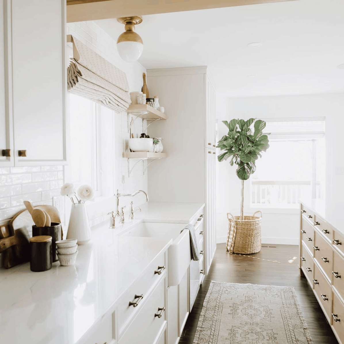 Jaclyn Peters Design kitchen: white cabinets with giant island and sink under window- Maison de Pax