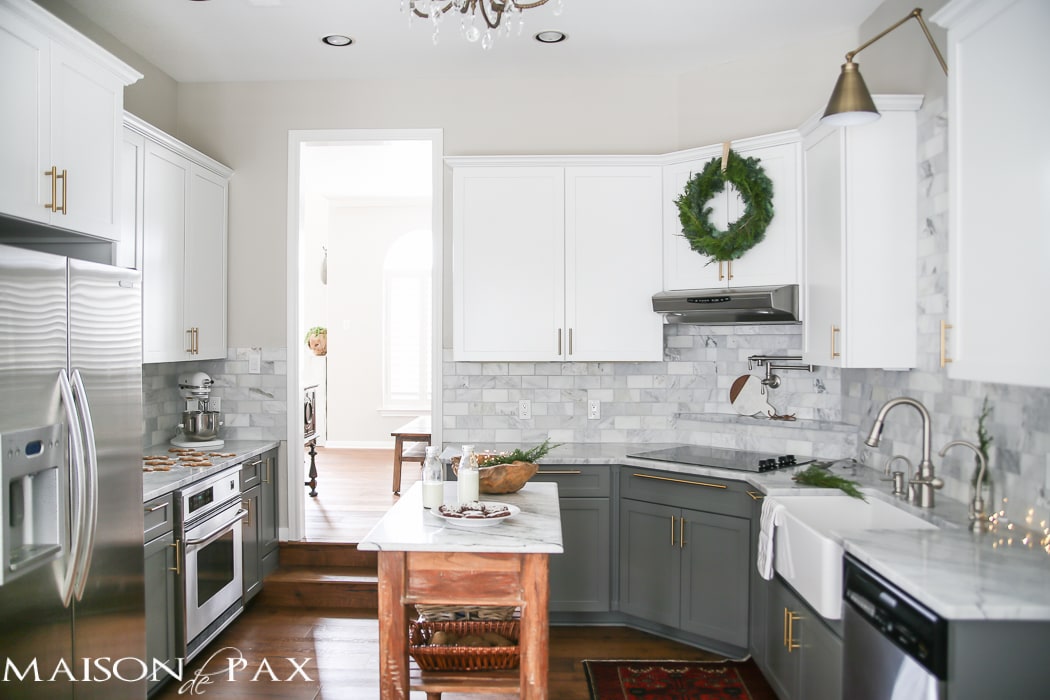 Gorgeous two-tone kitchen design with white upper cabinets, gray lower cabinets, carrara marble counters and marble subway tile backsplash- Maison de Pax