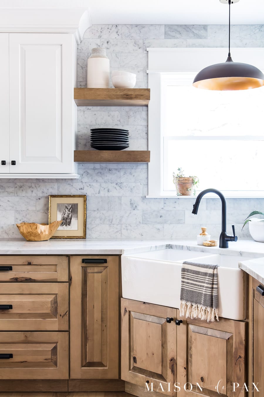 small succulent plant in window sill in kitchen with rustic wood lower cabinets and white upper cabinets