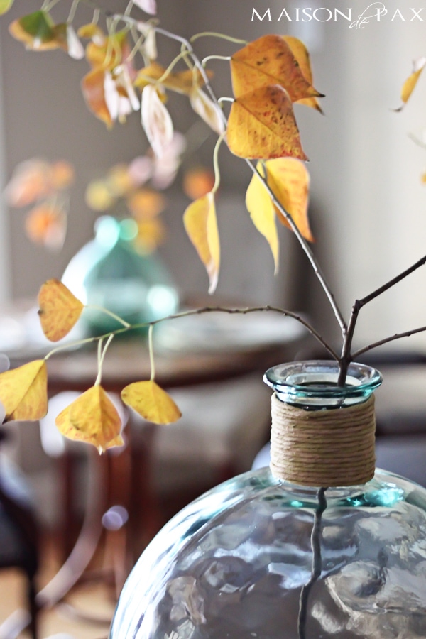 Lovely, simple Thanksgiving tablescape: a grand table and a side table with fall foliage centerpieces, simple neutral china settings, and a few pumpkins | aiweb9ygdry.cmersite.com