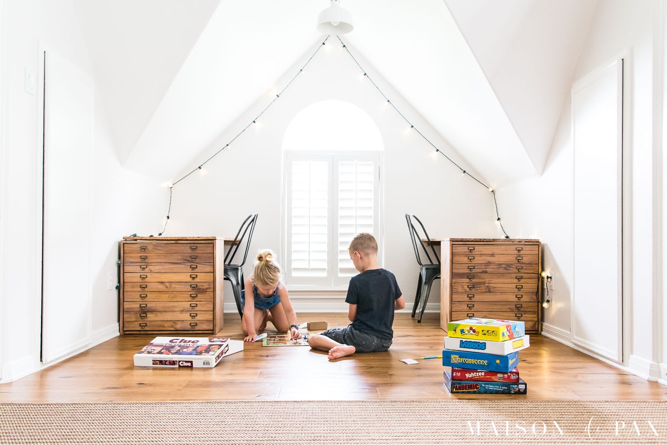 boy and girl in white room playing board game on floor | Maison de Pax