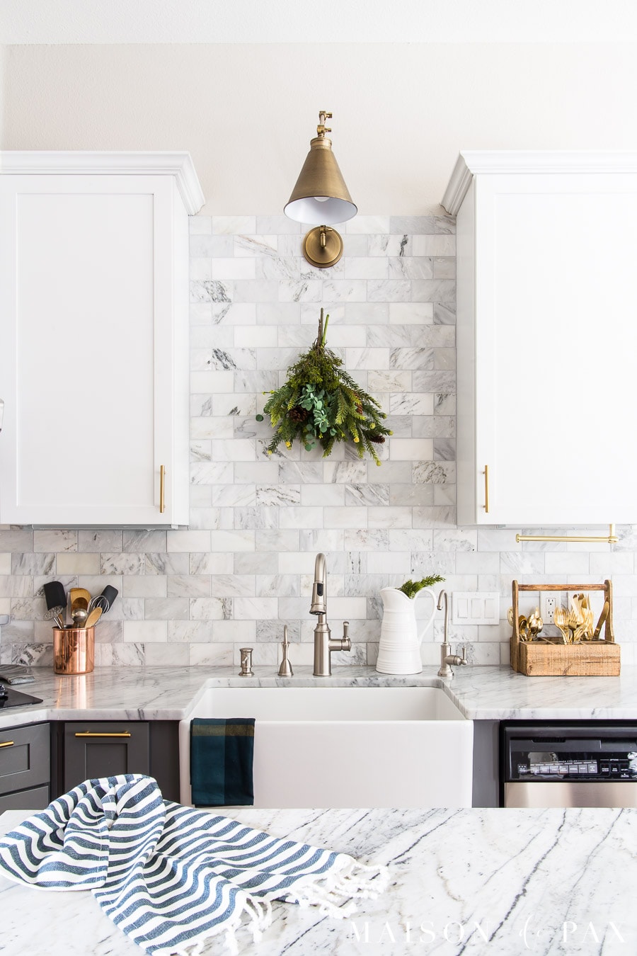 marble backsplash in a two toned kitchen with dark green holiday accents- Maison de Pax