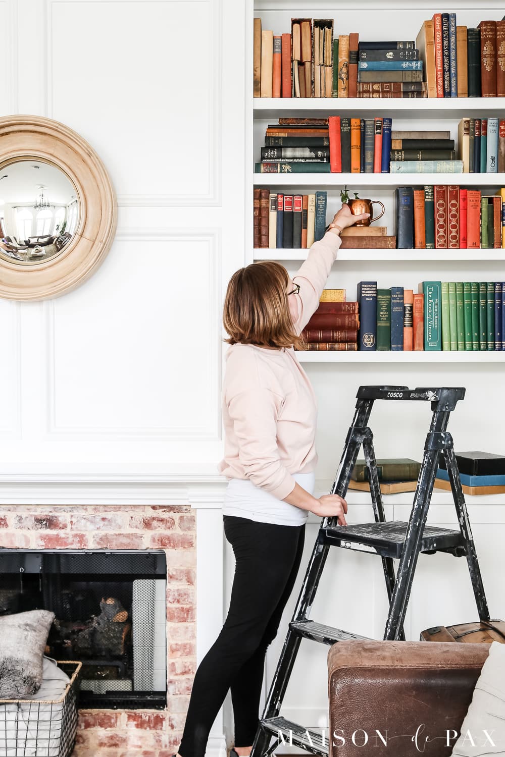 Designer decorating and styling a bookshelf- Maison de Pax