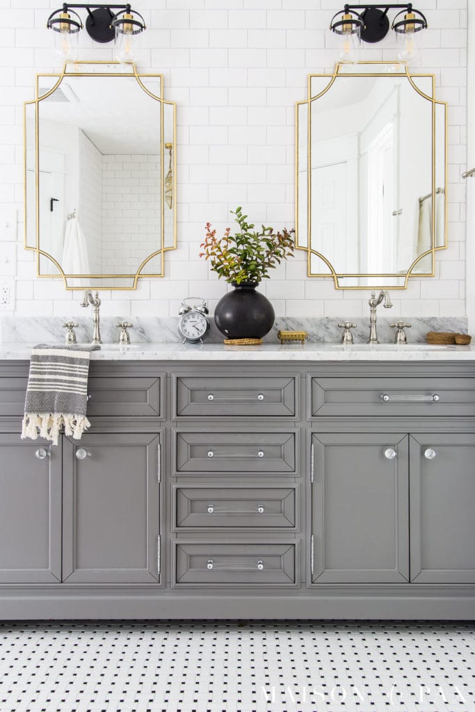 gray vanity with black and white basketweave tile floor