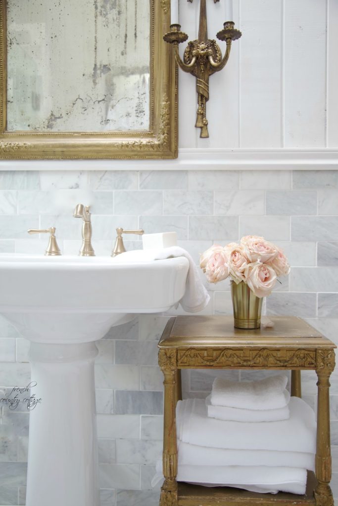 gold leaf mirror, antique washstand, and marble wall tile