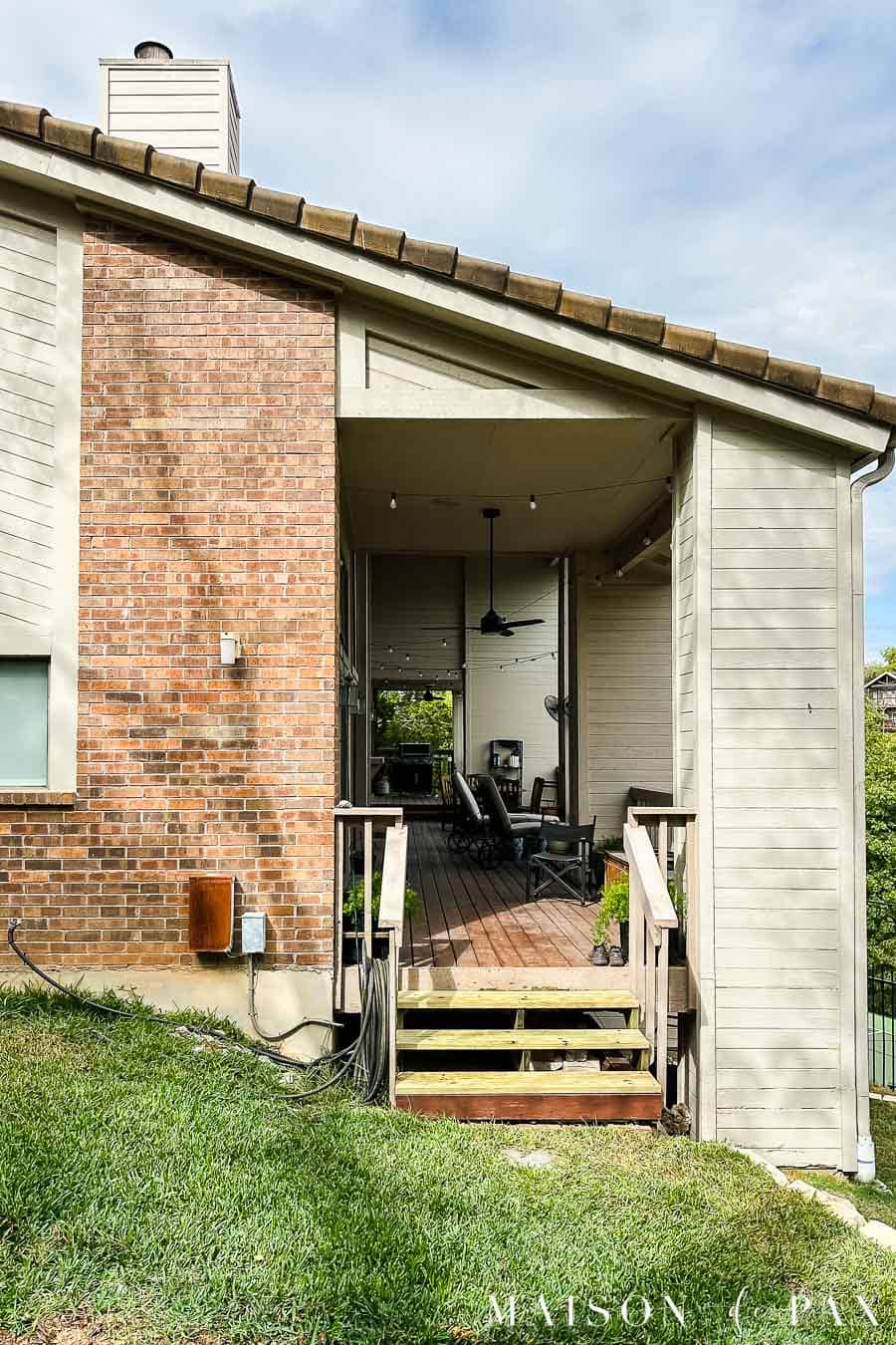 side of home with porch steps and an exterior sconce (before makeover)