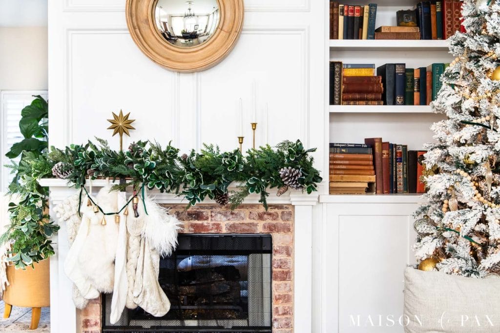 mantel with green garland, white stockings, and gold accents | Maison de Pax