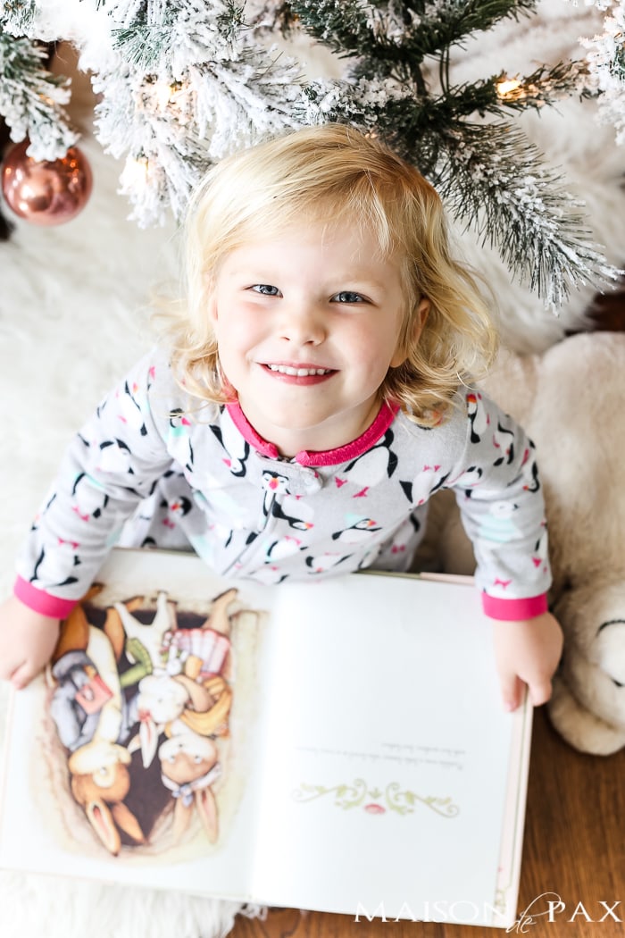reading children's books by the christmas tree
