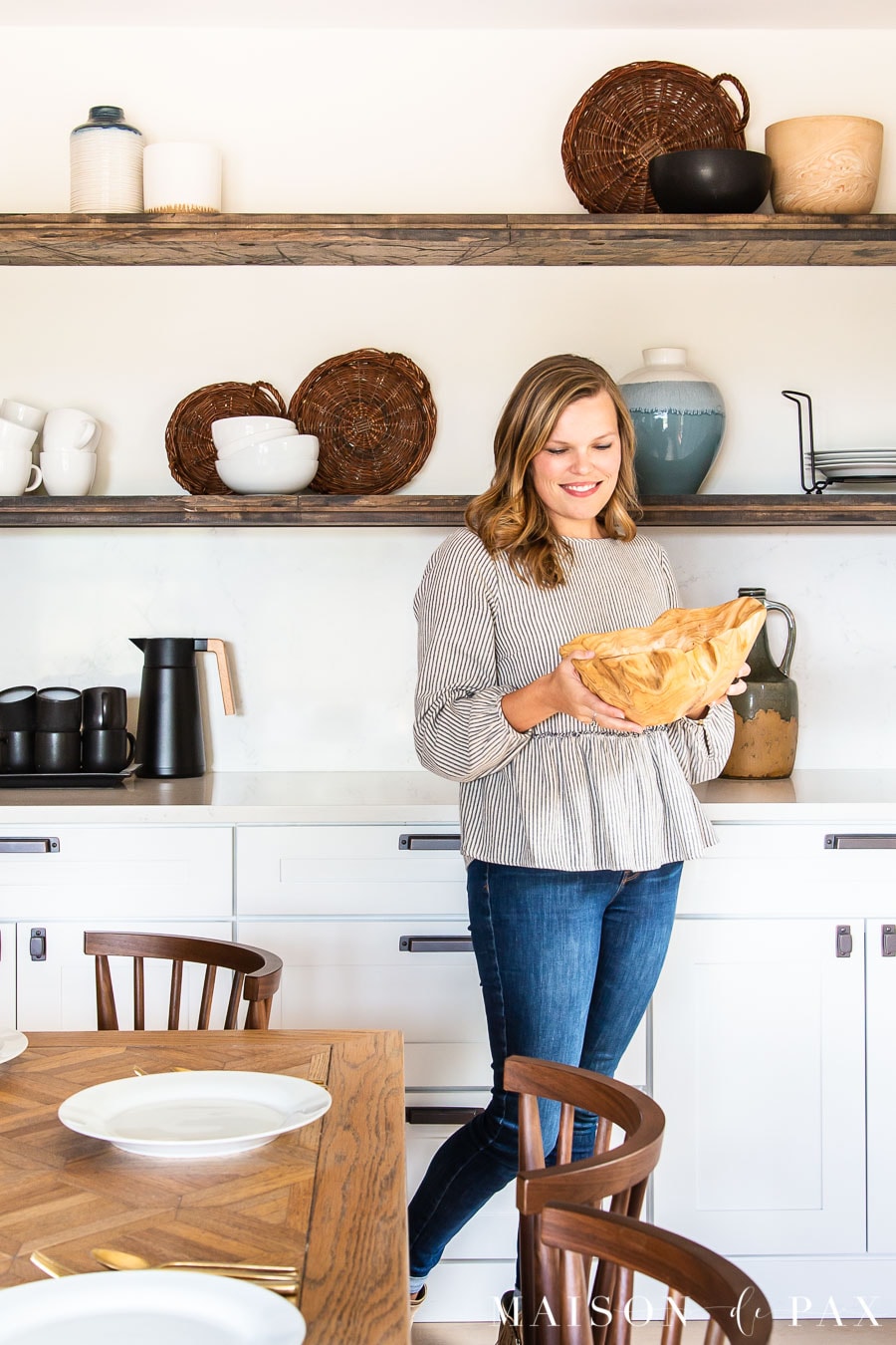 woman with wood bowl in dining room with open shelves | Maison de Pax