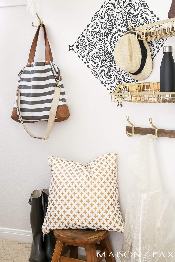 How to turn closet into mudroom: What an adorable space! Baskets and hooks turn a closet under the stairs into a functional mudroom space for a family.