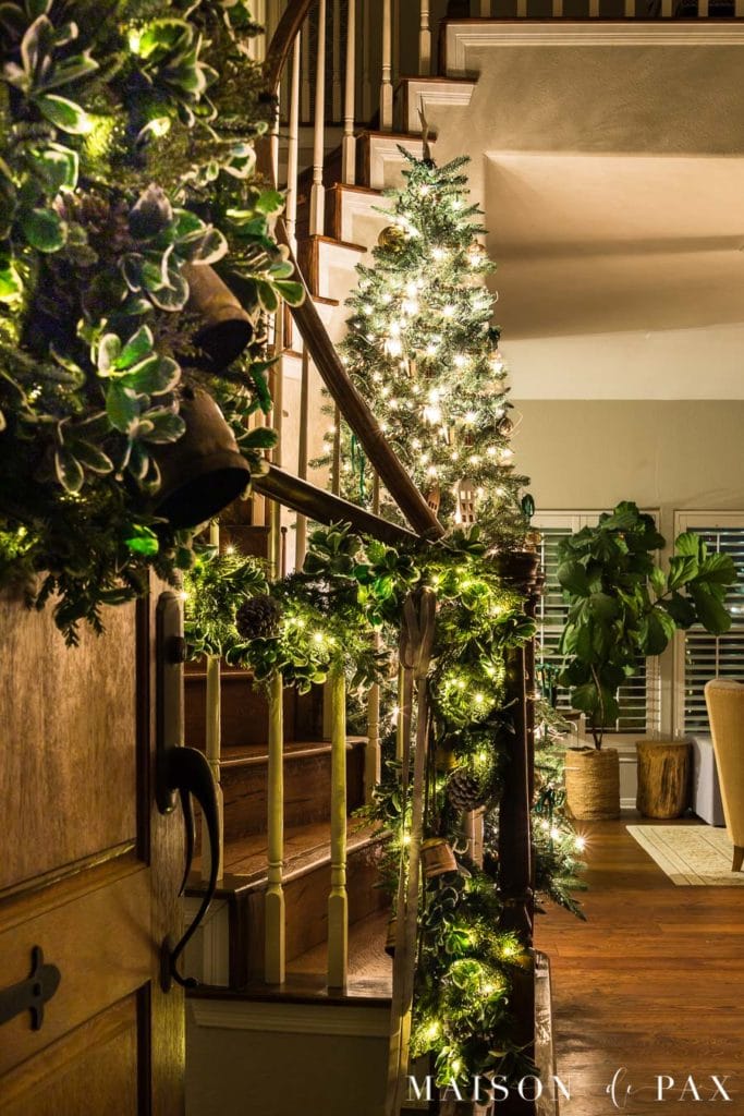 tall Christmas tree in stairwell lit up at night