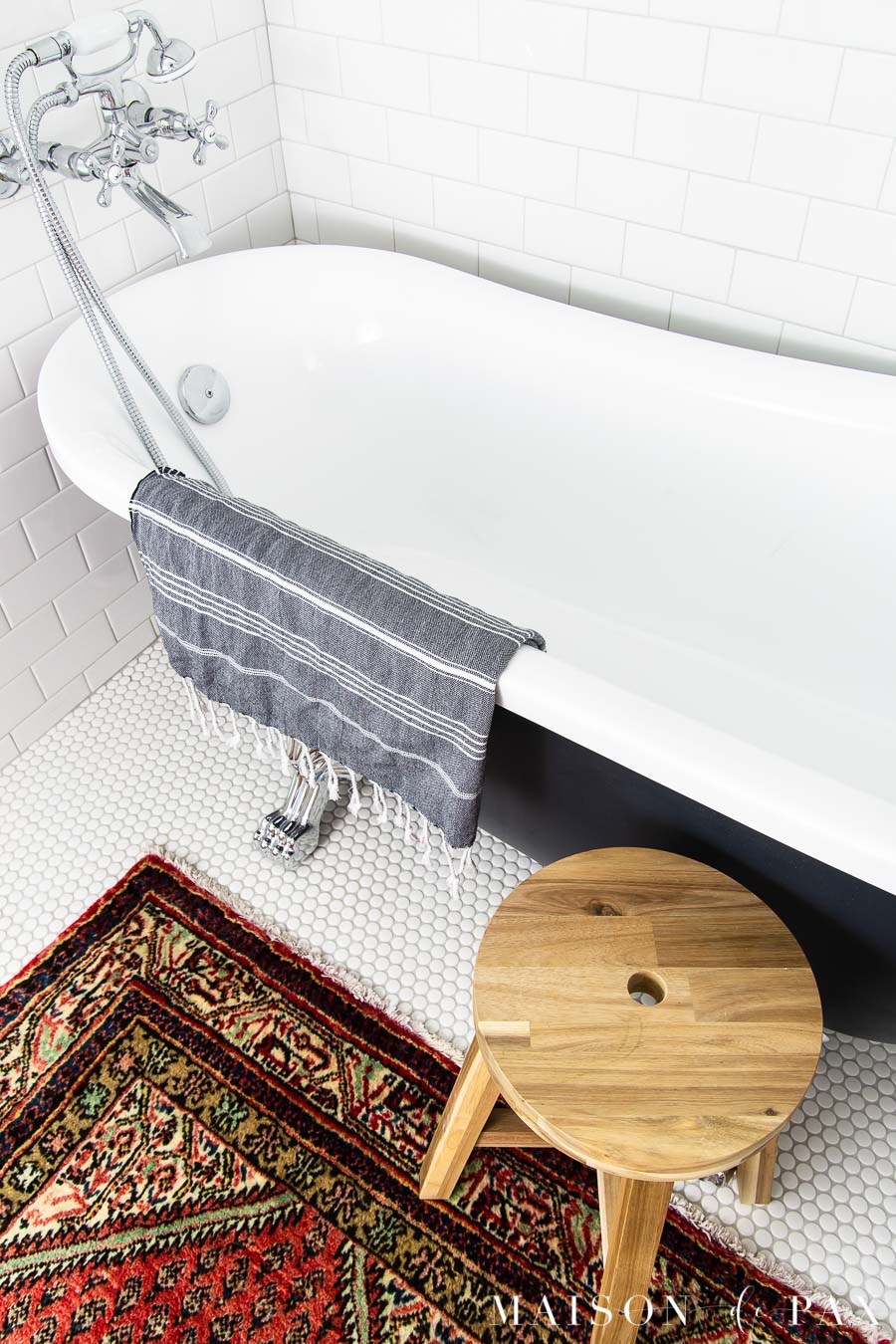 white penny tile on floor beneath black clawfoot tub | Maison de Pax