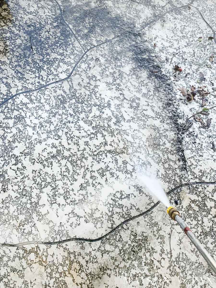 power washer spraying away dirt on a deck surface | Maison de Pax