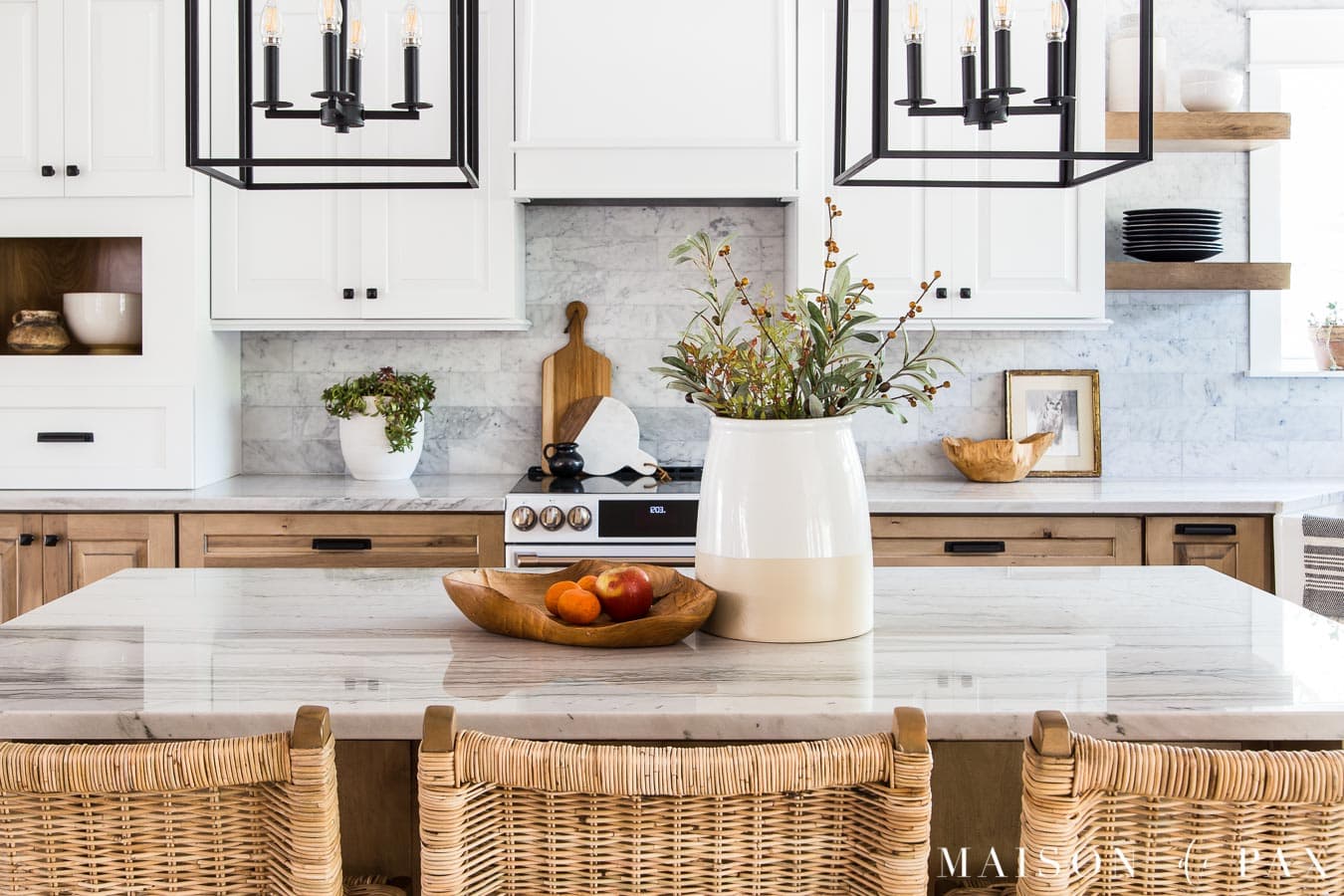 black kitchen pendant lights over white quartzite island