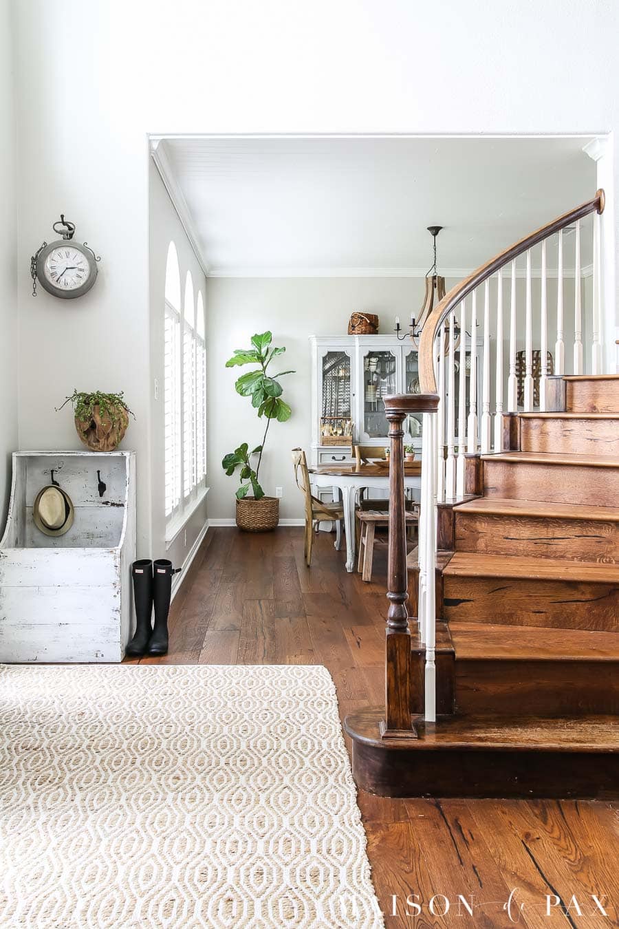 medium stained brown wood white oak flooring in foyer with staircase