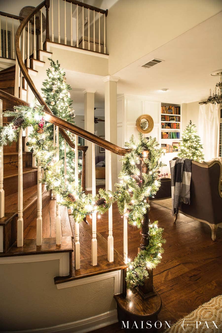 curved stairwell garland with christmas lights | Maison de Pax