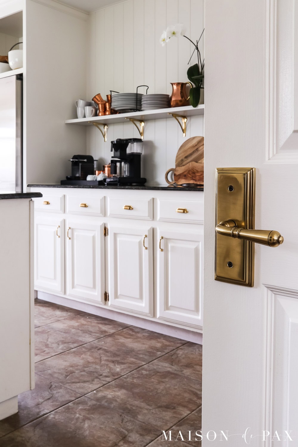 brass door handle and vintage cottage look kitchen with unlacquered brass hardware