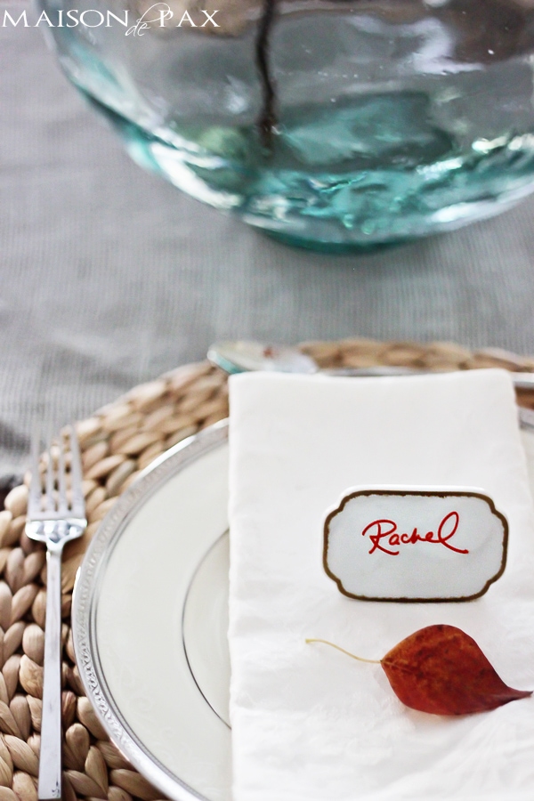 Lovely, simple Thanksgiving tablescape: a grand table and a side table with fall foliage centerpieces, simple neutral china settings, and a few pumpkins | aiweb9ygdry.cmersite.com