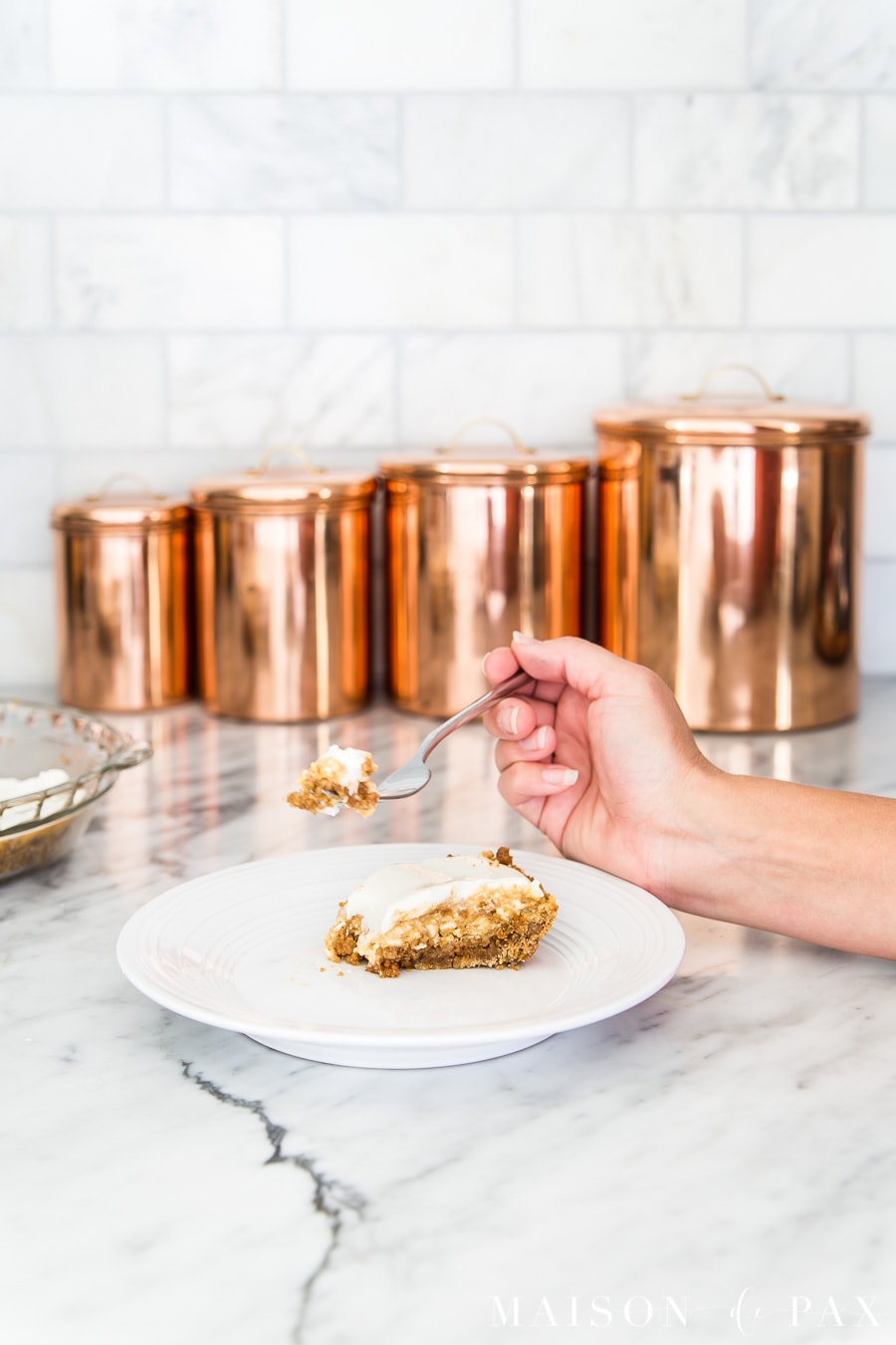 hand eating slice of sour cream pumpkin cheesecake | Maison de Pax