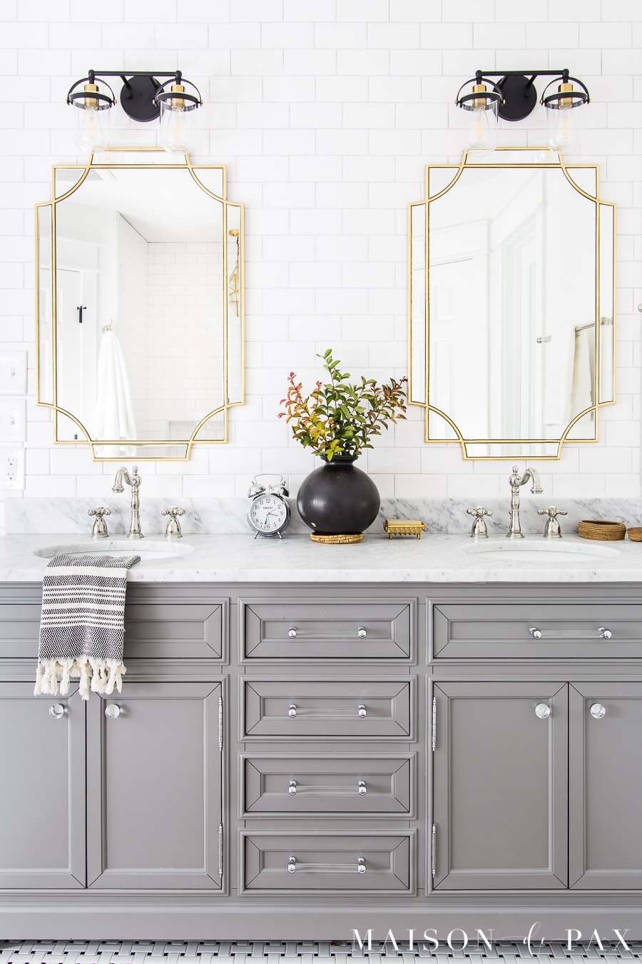 gray bathroom vanity in black and white tile bathroom