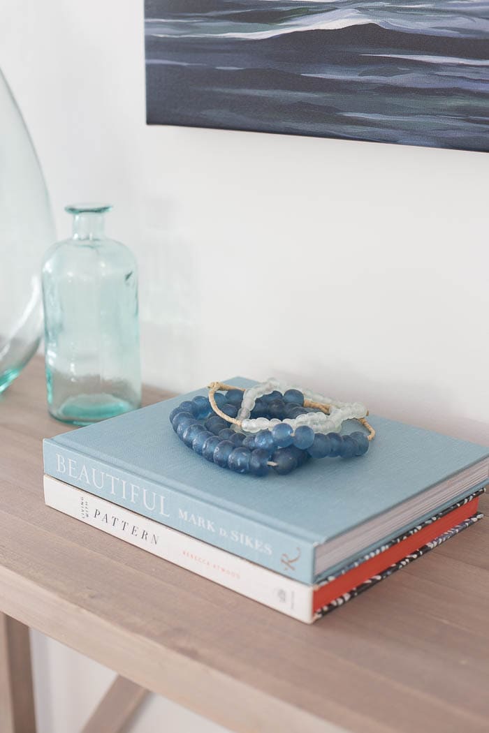 What a fun beachy vibe in this coastal living room! Blues, greens, weathered wood, and DIY wall art make it a beautiful, comfortable space.