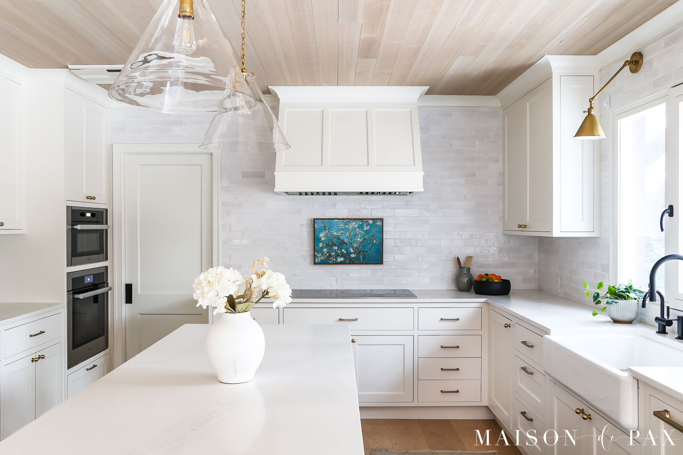 countertop to ceiling white brick tile around wooden range hood