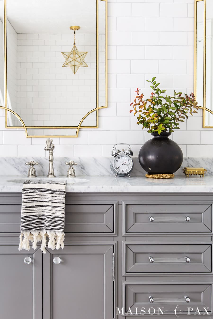 marble top vanity with polished nickel faucets and gold mirrors