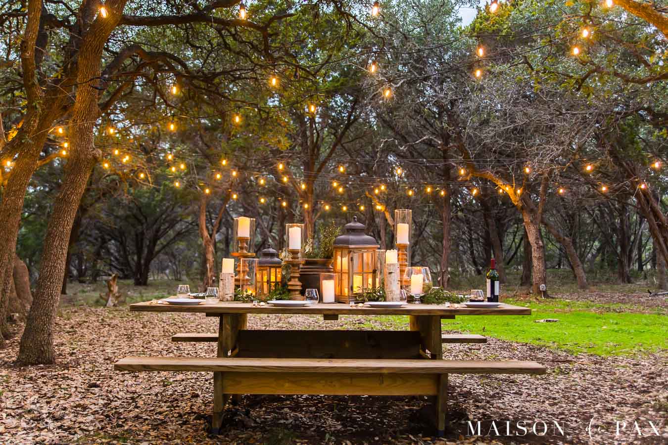 enormous picnic table with gorgeous centerpiece and string lights | maison de pax