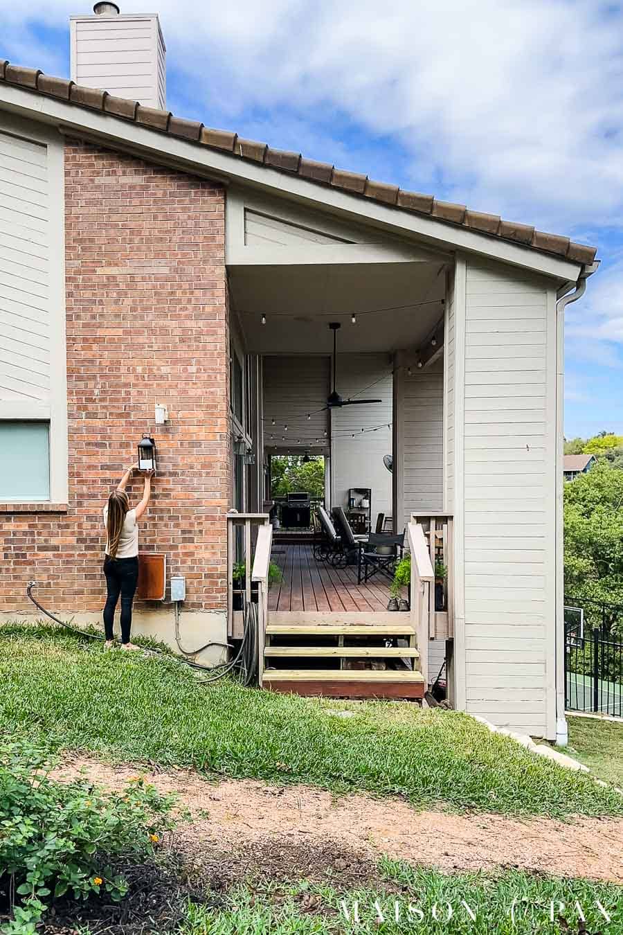 woman testing out outdoor wall sconces