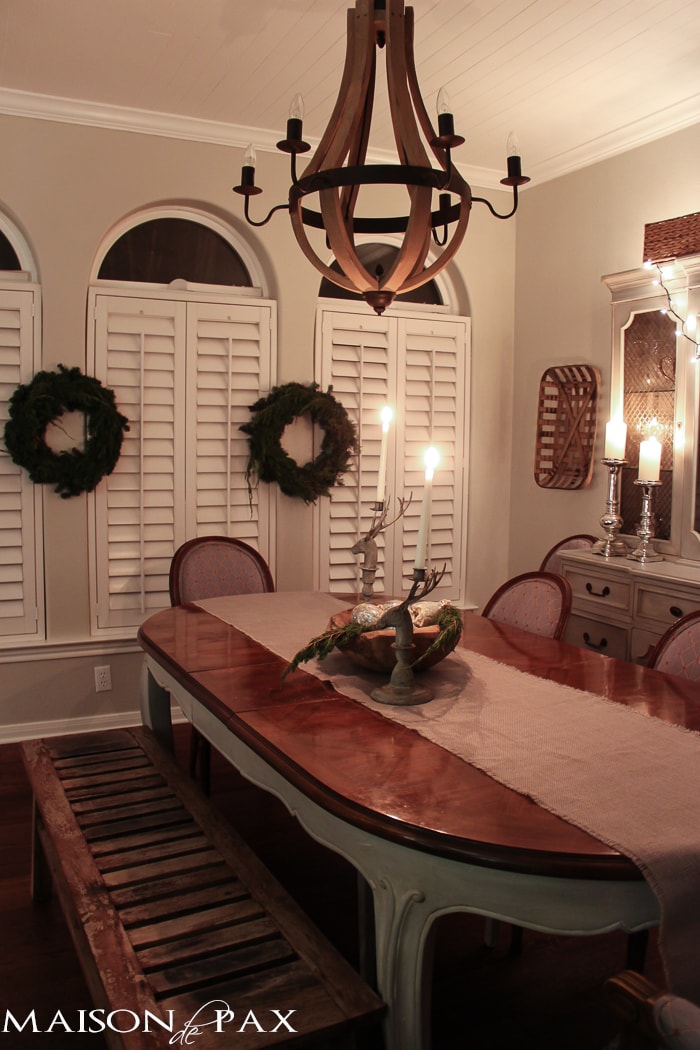 holiday decorating: Christmas table with reindeer candlesticks, string lights on china cabinet