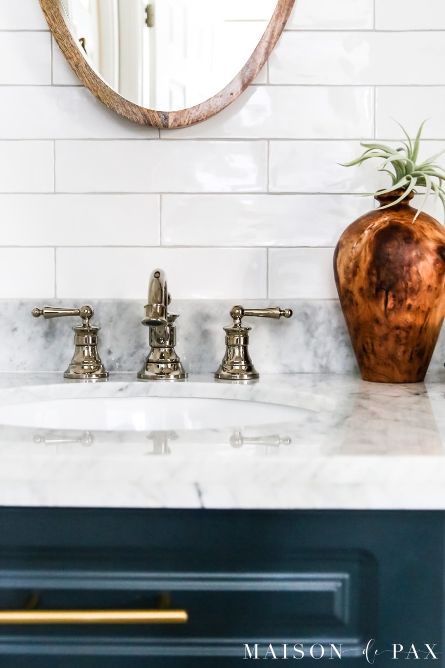 navy bathroom vanity with polished marble countertop and white handmade wall tile