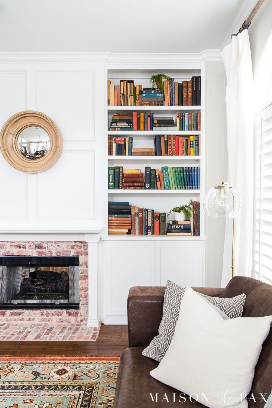 colorful antique books in white bookcase | Maison de Pax