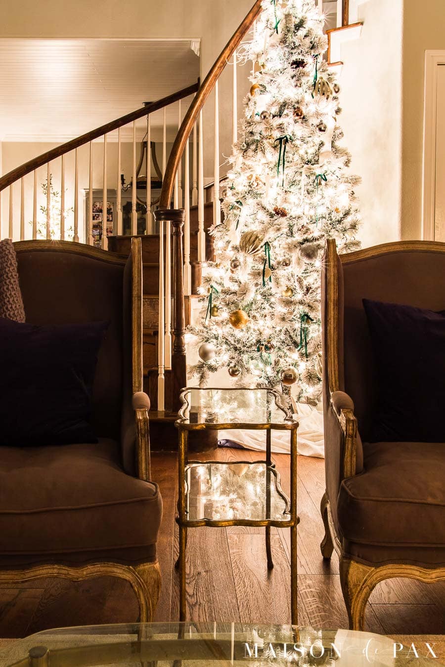 large flocked Christmas tree in curved stairway | Maison de Pax