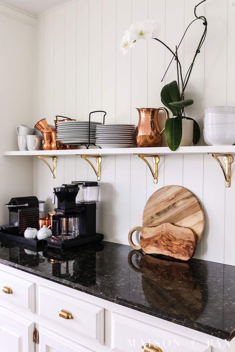 open kitchen shelf with everyday dishes, decorative items, and a houseplant