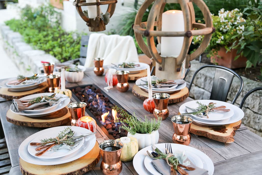 outdoor fall tablescape: lanterns, string lights, apple candles, and other cozy outdoor fall decorating ideas!
