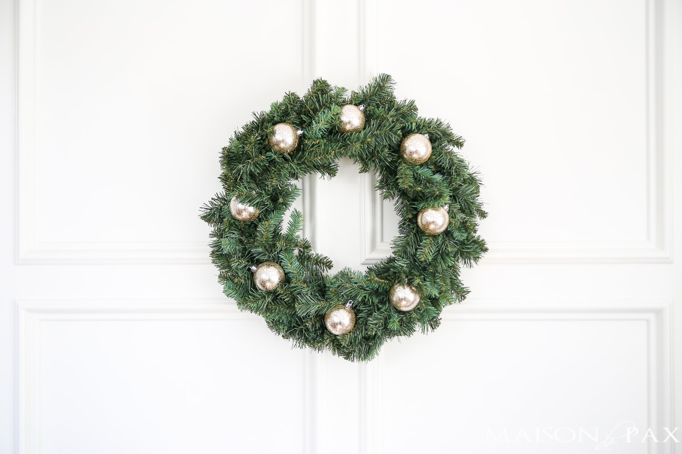 insert a few ornaments into a cheap wreath to great a gorgeous, expensive look (and click for 4 other easy, affordable wreath ideas!) #christmaswreath