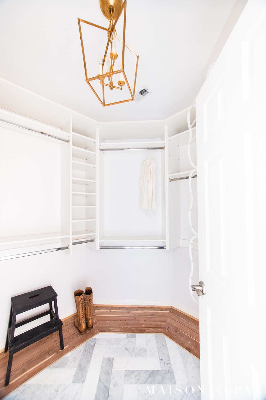 master closet with built in shelves, marble and cedar floors, and gold lantern chandelier | Maison de Pax